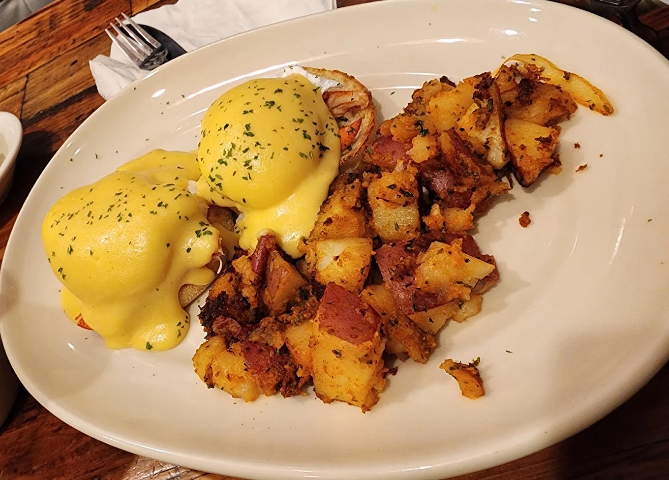Eggs Benedict with hollandaise sauce and home fries