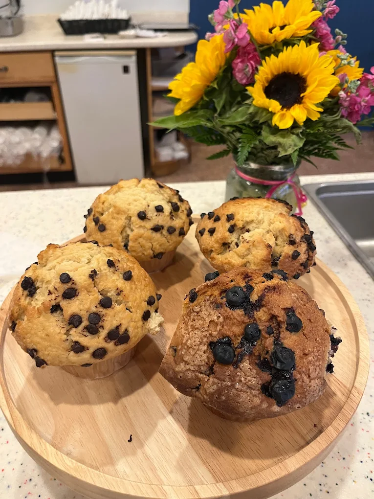 Freshly baked blueberry muffins with sunflowers in the background